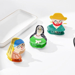 Artistic acetate hair claws featuring famous painting portraits on a ceramic tray