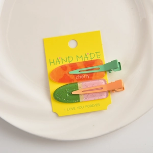 Detail of colorful fruit-themed seamless hair clips on a yellow display card