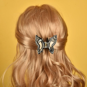 Schmetterling Haarklammer in Blau und Beige mit Cut-Outs in blondem gewelltem Haar