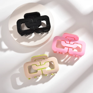 Pinces à cheveux modernes style chaîne en noir, rose et beige-vert sur décor géométrique