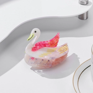 Elegante fermaglio per capelli a forma di cigno in acetato rosa su un piedistallo bianco