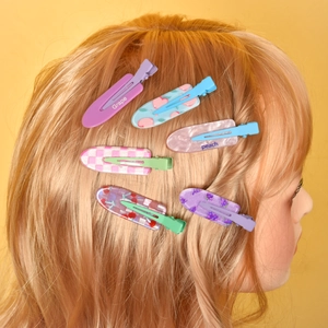 Set of 6 colorful fruit series hair clips with grape and peach patterns on a model