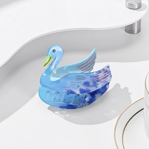 Dettaglio della clip per capelli a forma di cigno in acetato blu con venature marmo