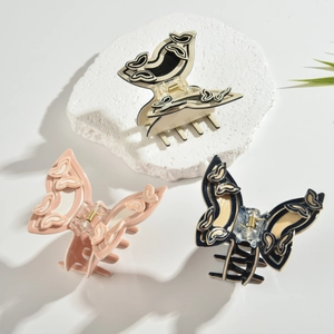 Detailansicht von drei Acetat-Schmetterlings-Haarklammern mit eleganten floralen Reliefs in Farben
