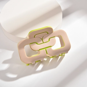 Vue détaillée de la pince à cheveux géométrique bicolore en beige et vert néon