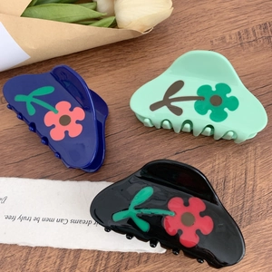 Chicke Acetat Blumen-Haarklammern in Marine, Minze und Schwarz auf Holztisch