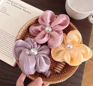 Gros plan de barrettes à fleurs avec perles dans un panier au style décoratif français