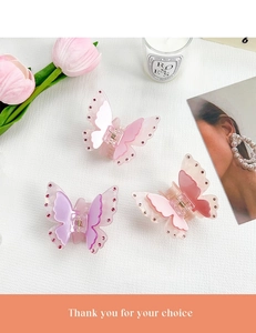 Close-up of three sparkling butterfly hair claws with rhinestones and metal springs
