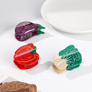 Detailed view of vegetable-shaped acetate hair claws in eggplant, pepper and cabbage designs