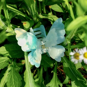 Détail d'une pince à cheveux papillon bleue à double couche avec paillettes dorées