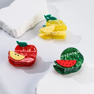 Three fruit-shaped hair clips in apple pineapple and watermelon styles on white stones