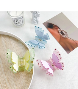 Macro detail of acrylic butterfly hair clips with sparkling rhinestones and double-layer wings