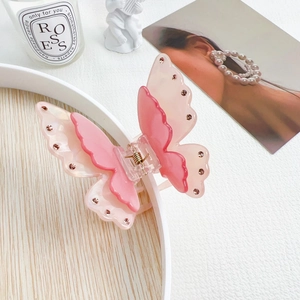Detail of elegant double-layered pink butterfly hair claw clip with sparkly rhinestones