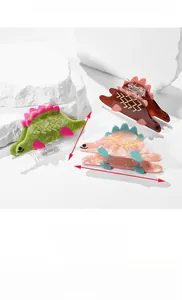Vue détaillée de pinces à cheveux dinosaure de 86mm en vert et ambre avec tailles