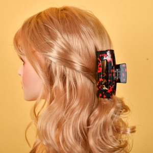 Detail of large square tortoiseshell hair claw clip in black and red resin on a model