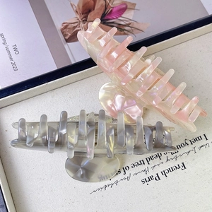 Detail of high-quality large acetate starfish hair claws with iridescent shell gloss finish