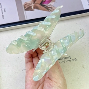 Detail of mint green marble hair claw clip with large teeth and strong metal spring