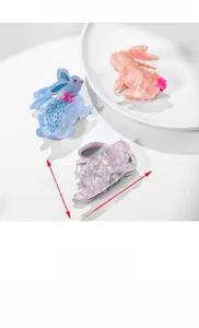 Detail view of acetate rabbit hair claws in blue, pink, and purple with bow accents