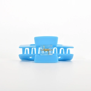 Close-up of sky blue large square hair claw clip with golden metal spring and smooth finish