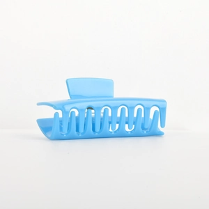 Detail view of large sky blue acetate hair claw clip with glossy finish and wavy teeth