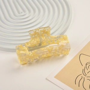 Macro shot of large square creamy yellow marble acetate hair claw clip with minimalist design