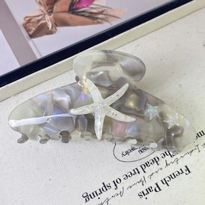 Close-up of marble grey acetate hair claw clip featuring sparkling starfish details