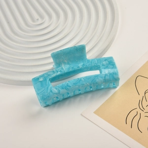Detail of blue marble texture acetate hair claw clip on minimalist ripple tray
