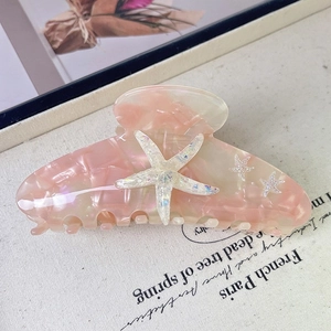 Detail of pink acetate starfish hair claw clip with iridescent glitter and sturdy teeth