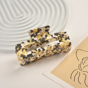 Detail of a large rectangular hair claw clip with a yellow and black tortoiseshell pattern