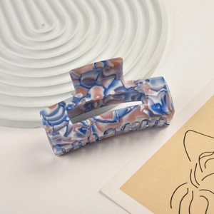 Detail of blue and pink marble textured acetate rectangular hair claw clip with silver spring
