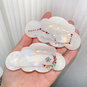 Iridescent cloud-shaped hair claw clips featuring rhinestone moon and constellation designs