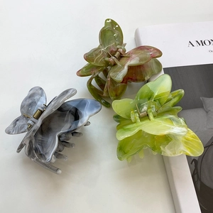 Trois pinces à cheveux papillon en acétate avec textures marbrées bleu, vert et jaune