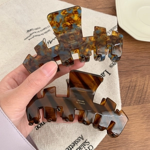 Large acetate hair claw clips in tortoiseshell and marbled blue patterns for thick hair