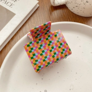 Close-up of a colorful checkered square claw clip with a high-quality metal spring