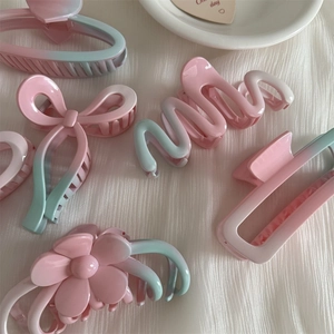 Collection of matte resin hair claws with pink and blue ombre gradient designs