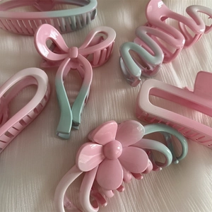 Detail of assorted hair claw clips featuring pink and blue gradient resin designs