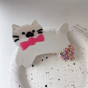Détail de la pince à cheveux chat blanc en acétate avec nœud rose et perles scintillantes