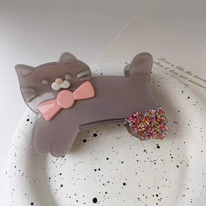 Détail d'une pince à cheveux chat en acétate avec nœud rose et finition pailletée colorée