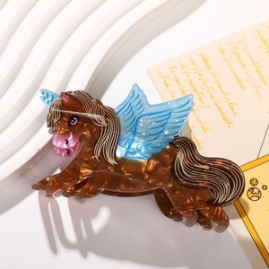 Close-up of tortoise shell lion claw clip with blue wings on a white textured plate