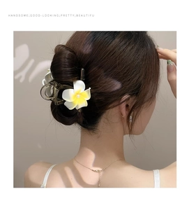 Détail de la pince à cheveux frangipanier avec perle blanche et pétales dégradés jaunes