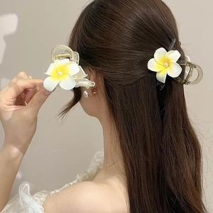 Pince à cheveux fleur de frangipanier blanche et jaune présentée à la main et sur modèle