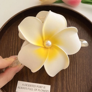 Détails de la pince à cheveux fleur de frangipanier avec pétales dégradés et perle centrale