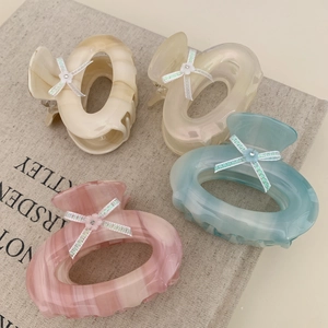 Set of four tortoiseshell acetate claw clips with glitter bows and floral accents