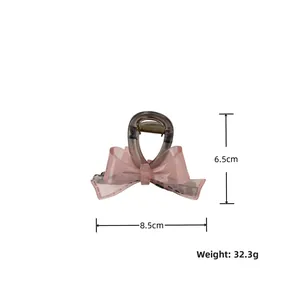 Detail view of transparent grey hair claw clip with pink tulle bow, size 8.5cm by 6.5cm