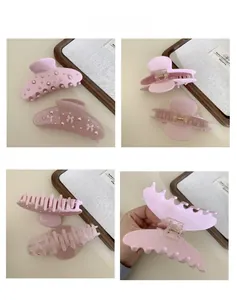 Detail shots of two pink acetate hair claws with pearls and ribbon bow decoration