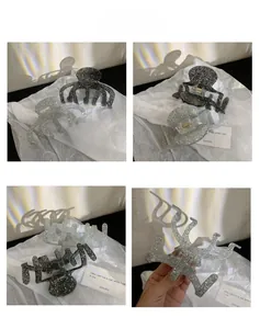 Detailed close-up of large glitter hair claw clips in shimmering silver and black colors