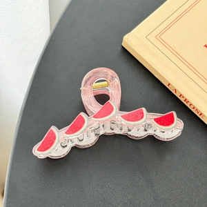 Detail of pink jelly hair claw clip featuring vibrant watermelon patterns and gold spring