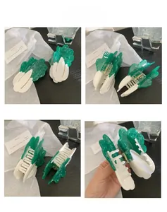 Detail view of large cabbage-shaped hair claw clip with acetate green and white texture