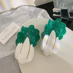 Chic green cabbage acetate hair claw clip set on a white ceramic plate for elegant styling