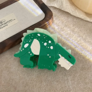 Detail of emerald green dinosaur hair claw with acetate finish and crystal embellishments